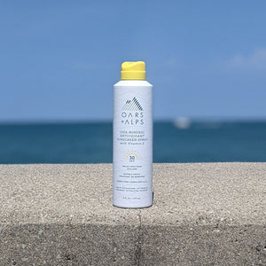Stylized photo with ocean view of Oars & Alps 100% mineral Spray Sunscreen SPF 35