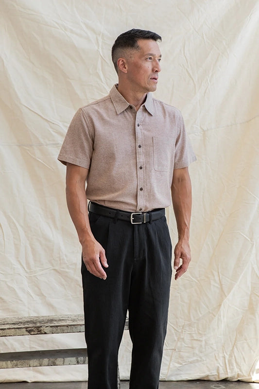 Model wearing Bridge & Burn Malcom short sleeve chambray shirt in rust chambray color, front  view