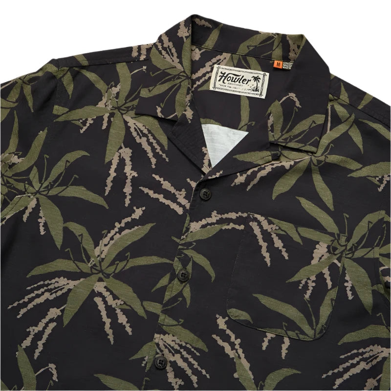 Howler Brother's Momoloha Shirt, lily negatives pattern, black with green, flat lay close up view